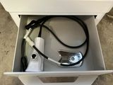 un tiroir blanc contenant un appareil électronique et un chargeur