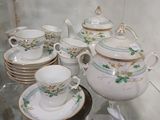 une vitrine en verre dans laquelle sont exposées diverses tasses à thé et soucoupes