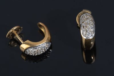 two pairs of gold and diamond earrings on a black surface