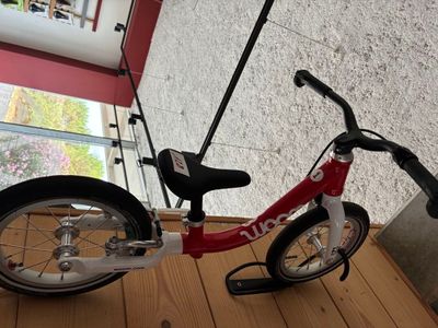 un vélo posé par terre devant une fenêtre