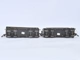 two black train cars sitting side by side on a white surface