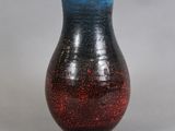 un vase rouge et bleu posé sur une table