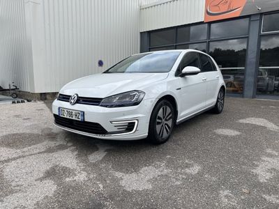 une Volkswagen e-Golf blanche garée devant un immeuble