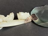 a spoon and a spoon with a carved object on it
