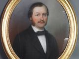 portrait d'un homme en costume et nœud papillon dans un cadre doré