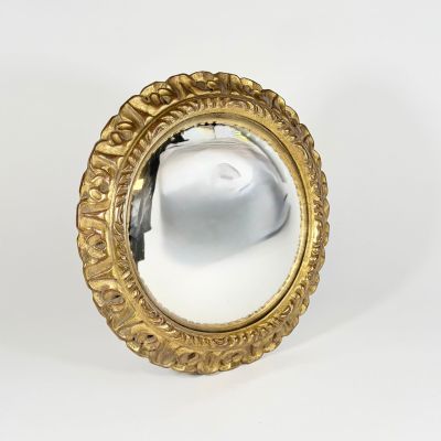 mirror with a gold frame on a white background with a reflection of a person in the mirror