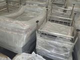 de nombreux lits dans une chambre, emballés dans du plastique