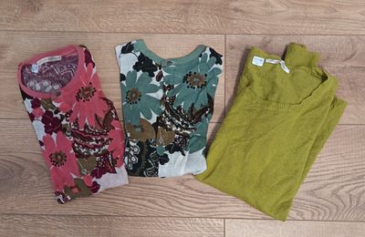 three women ' s clothing laying on a wooden floor next to each other