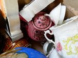 many cups and saucers in a box with a teapot