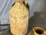 two old vases sitting next to each other on a blue cloth