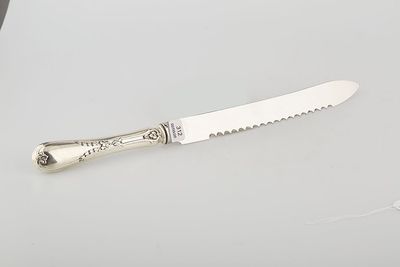 a silver plated knife on a white surface with a knife in the middle