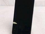 the back of a black cell phone sitting on top of a white table