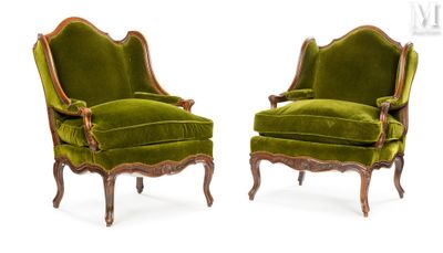 une paire de fauteuils en velours vert avec des pieds en bois sculpté