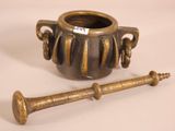 a small vase with a wooden handle next to it
