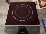 a black stove top with a blue burner on top of it