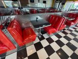 a checkered floor in a diner with red chairs