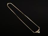 un collier en or orné d'une pierre verte sur fond noir