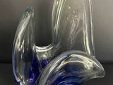 une sculpture en verre bleu et transparent posée sur une table