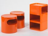 deux tabourets en plastique orange et une étagère posée sur un plan de travail blanc