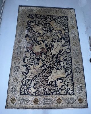 un tapis posé à même le sol, dans un coin d'une pièce aux murs blancs
