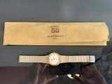 someone is holding a watch in front of a box with a watch on it