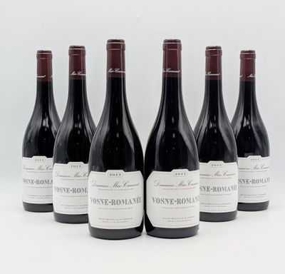 six bottles of wine are lined up in a row on a white surface