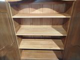 a wooden shelf in the corner of a room