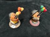 two figurines of a man with a golf club and a bag of golf balls