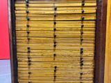 une vieille armoire en bois comportant de nombreux tiroirs et surmontée d'autres tiroirs