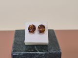 a pair of earrings sitting on top of a marble block