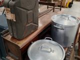 deux grands récipients en métal posés sur une table en bois