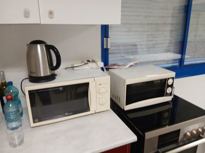 deux fours à micro-ondes posés sur une cuisinière dans une cuisine