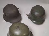 three military helmets sitting on top of a table next to each other