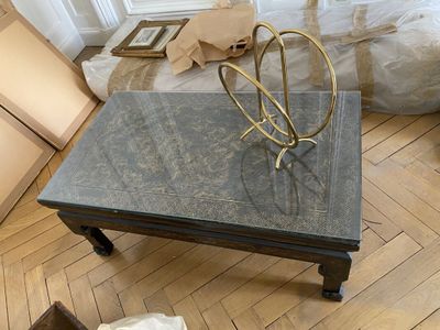 une table basse avec un plateau en marbre posée sur un parquet en bois massif