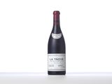 a bottle of red wine sitting on top of a white table