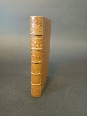 a book that is sitting on a table next to a cup