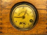 an old wooden clock sitting on top of a table next to a wall