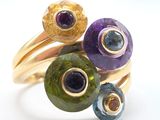 a close up of a ring with different colored stones on it
