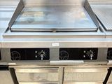 a stove top in a commercial kitchen with two ovens
