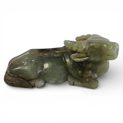 sculpture en jade représentant un taureau couché sur une surface blanche