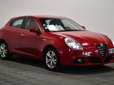 a red car is parked in a room with a checkered floor