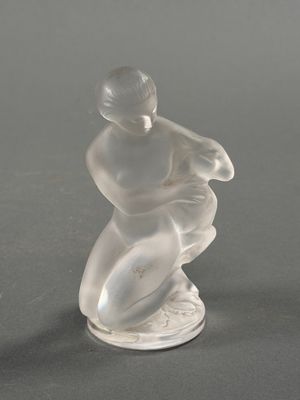 une figurine en verre représentant un homme sur une planche de surf