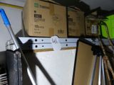 une pile de cartons posée sur une étagère, à côté d'une serpillière