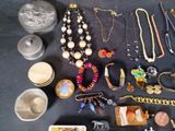 many different types of necklaces and bracelets laid out on a table