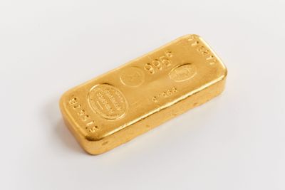 une barre d'or posée sur une surface blanche