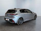 the rear end of a silver car in a white room