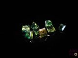 a close up of a group of green crystals on a black surface
