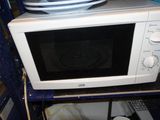 a microwave that is sitting on a shelf in a room