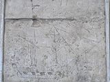 a stone plaque with a ship on it in front of a building