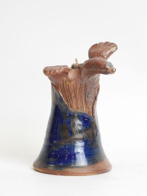 a blue vase with a bird on it on a white surface